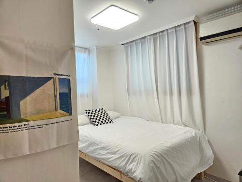 a small bedroom with a bed and a window at Coco Stay in Seoul
