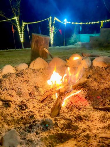 a fire pit in the sand at night at Sainj Riverside Cottages in Sainj