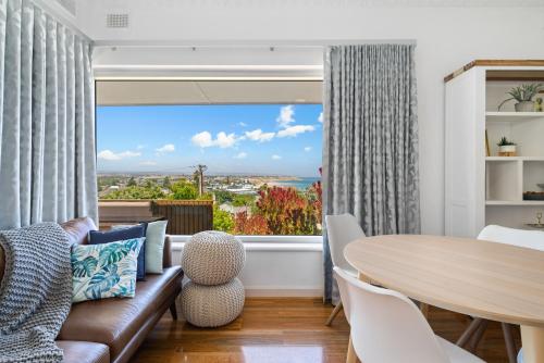 a living room with a table and a large window at Ocean View in Port Noarlunga in Port Noarlunga