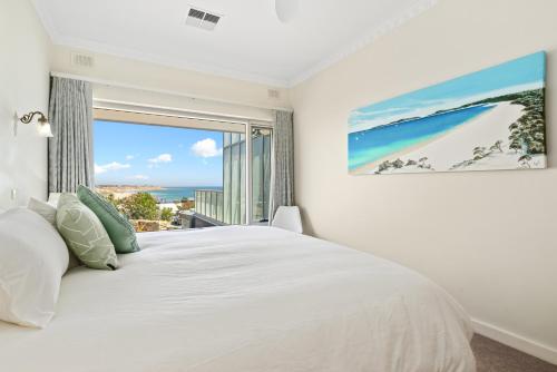 Port NoarlungaOcean View in Port Noarlunga的卧室里有一张白色的床和一扇大窗户