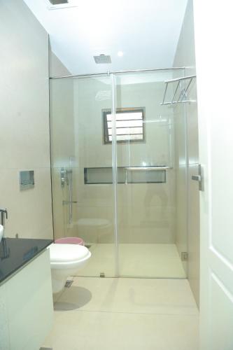 a bathroom with a glass shower and a toilet at Wariyam Heritage in Trichūr