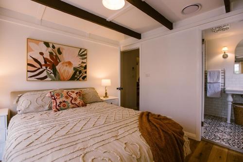 Pet-Friendly Highlands Home with Fireplace في بوندانون: غرفة نوم بسرير ودهان على الحائط