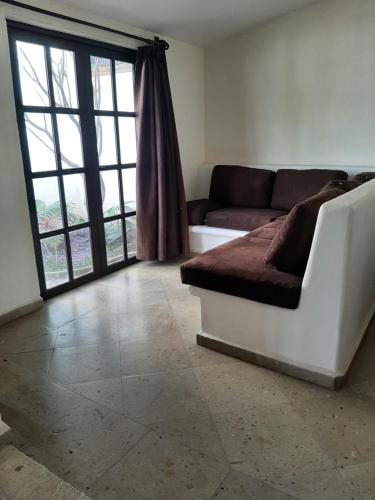 - un salon avec un canapé et une grande fenêtre dans l'établissement Quinta Zana Hotel Boutique Sc, à Cuernavaca