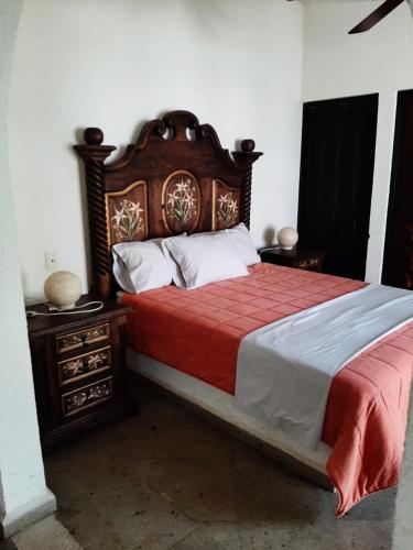 - une chambre avec un grand lit et une tête de lit en bois dans l'établissement Quinta Zana Hotel Boutique Sc, à Cuernavaca
