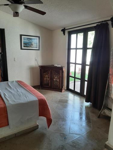 - une chambre avec un lit et une porte coulissante en verre dans l'établissement Quinta Zana Hotel Boutique Sc, à Cuernavaca