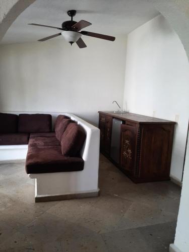 - un salon avec un canapé et un ventilateur de plafond dans l'établissement Quinta Zana Hotel Boutique Sc, à Cuernavaca