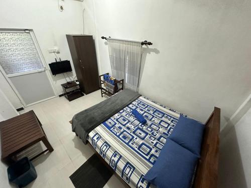 una camera da letto con un letto con lenzuola blu e una finestra di Rodrigo Cottage a Negombo