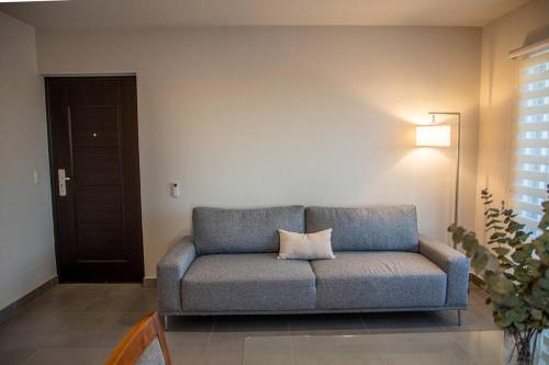 a couch in a living room with a pillow on it at Downtown Beach Condo w/ Pool in Cabo San Lucas