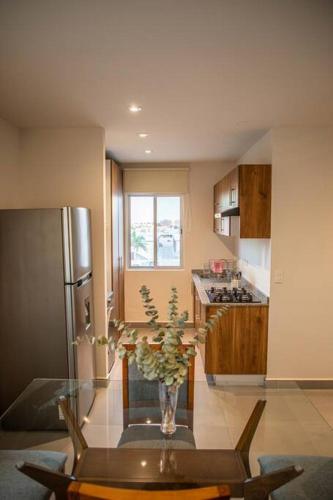 a kitchen with a table and a vase of flowers at Downtown Beach Condo w/ Pool in Cabo San Lucas
