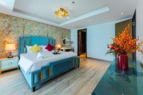 a bedroom with a blue bed and a vase of flowers at SeaHaven Panorama Nha Trang Superview Apartments in Nha Trang