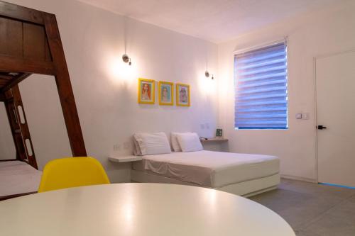 a room with a bed and a table and a window at OASIS TROPICAL HOTEL in Santa Marta