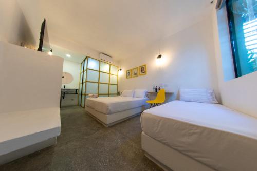 a hotel room with two beds and a desk at OASIS TROPICAL HOTEL in Santa Marta