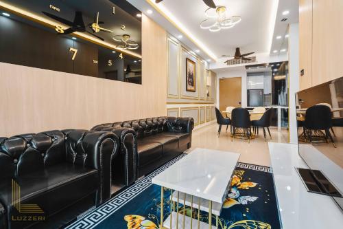 een wachtkamer met zwarte leren banken en een tafel bij Legasi Kampung Baru Guesthouse in Kuala Lumpur