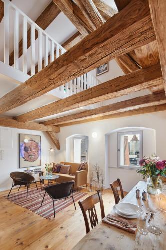 a living room with wooden ceilings and a table and chairs at Engelwirt Hotel & Apartments in Berching