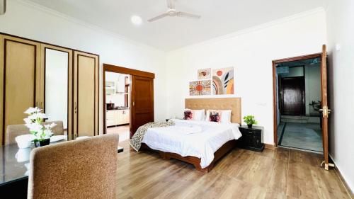 a white bedroom with a bed and a mirror at OLIVE Service Apartments DLF Galleria Gurgaon in Gurgaon