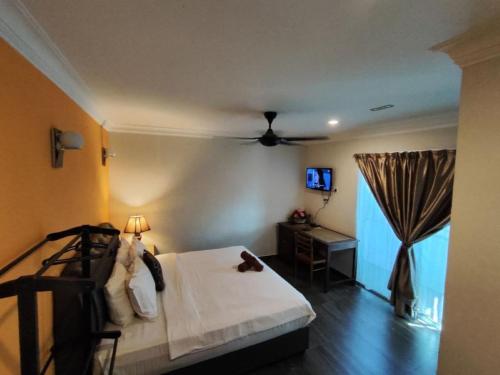 a bedroom with a bed with a ceiling fan at Sweet Cenang Memories Inn in Pantai Cenang