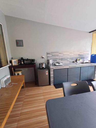 a room with a kitchen with a table and a counter at Welcome to Our Farm House in Del Rosario