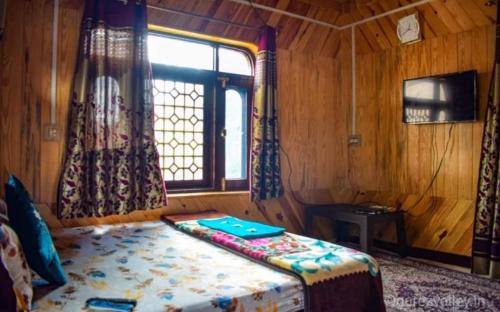 ein Zimmer mit einem Bett in einem Holzzimmer mit einem Fenster in der Unterkunft Hotel kaka palace Gurez in Kanzalwan