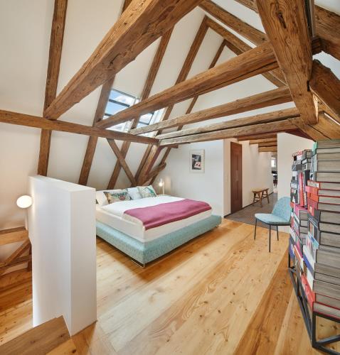a bedroom with a large bed and wooden ceilings at Engelwirt Hotel & Apartments in Berching