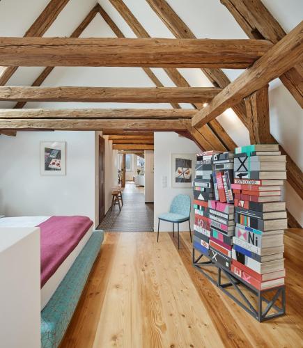 a bedroom with a bed and a stack of books at Engelwirt Hotel & Apartments in Berching