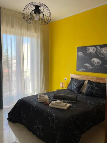 a bedroom with a black bed with a yellow wall at B&B D'Aponte Home in Volla