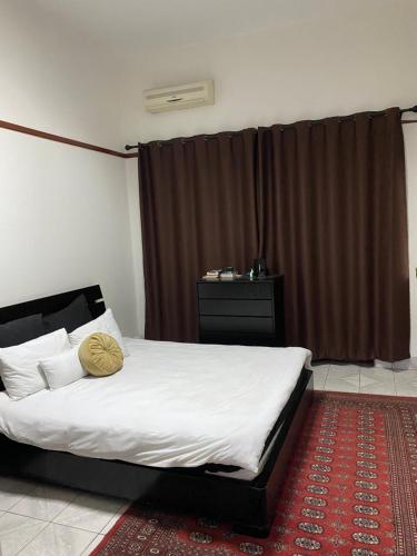 a bedroom with a large bed with a red carpet at MozBnb in Maputo