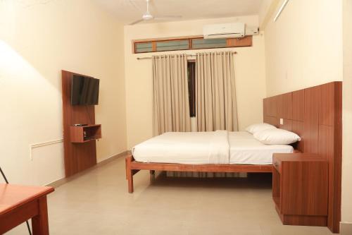 a bedroom with a bed and a television in it at Wariyam Heritage in Trichūr