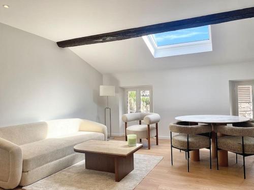 ein Wohnzimmer mit einem Sofa und einem Tisch in der Unterkunft Cannes appartement 2 chambres - 19JDR in Cannes