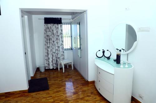a white bathroom with a sink and a mirror at HAILSTONE HOME STAY in Ooty