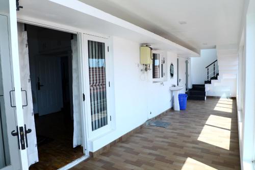 a hallway of a home with white walls and stairs at HAILSTONE HOME STAY in Ooty