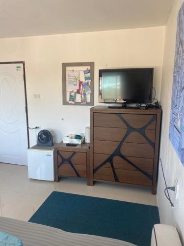 a living room with a tv on a wooden dresser at English owned Homestay and Yoga in Chalong 