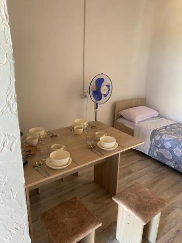 een kleine kamer met een houten tafel met borden erop bij Гостевой дом Самга in Akshi