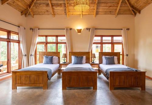 two beds in a room with windows at Ngorongoro Marera Mountain View Lodge in Karatu