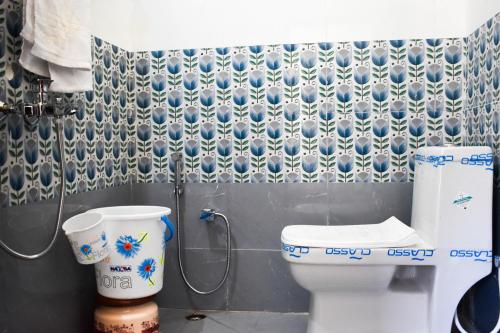 a bathroom with a toilet and a shower in it at Atithi Home Stay - Himalayas view in Chaukori
