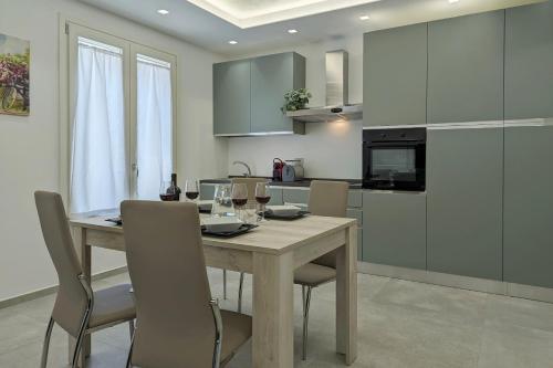 a kitchen with a wooden table and chairs with wine glasses at Minimal Apt Centro Wifi Clima by WeHostYou in Porto San Giorgio