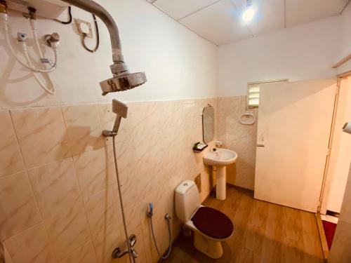 a bathroom with a shower and a toilet and a sink at Adventure Base camp in Kitulgala