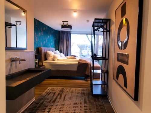 ein Schlafzimmer mit einem Bett und ein Badezimmer mit einem Waschbecken in der Unterkunft Hotel KUMP365 in Paderborn