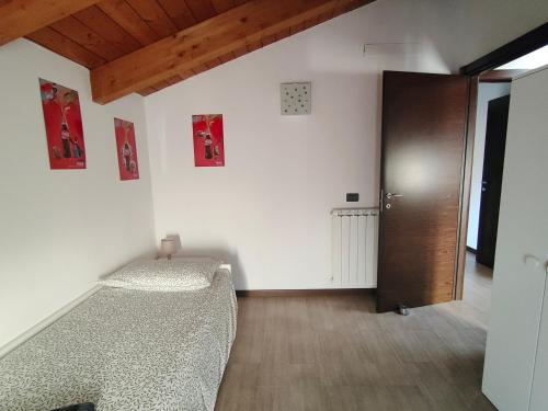 a room with a bed and a wooden door at La casetta del borgo in Medicina