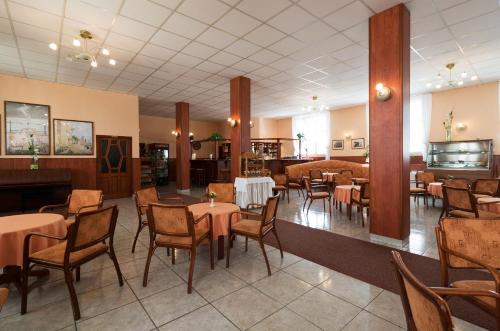 a restaurant with tables and chairs in a room at Ensana Pro Patria in Piešťany