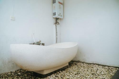 a white bath tub sitting in the corner of a room at Umadesa villa in Penginyahan