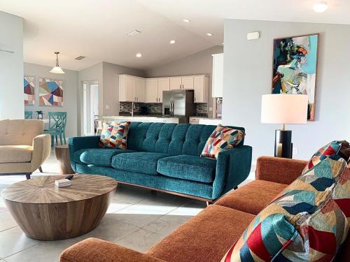 a living room with a blue couch and a table at The Cape Escape Pet-Friendly Sleeps 7 in Cape Coral