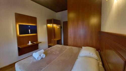 una camera da letto con un letto con due asciugamani arrotolati di Castle Hotel a Gjirokastër