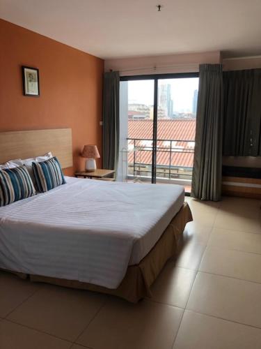 a bedroom with a large bed and a balcony at Vogue Pattaya Hotel in Pattaya Central