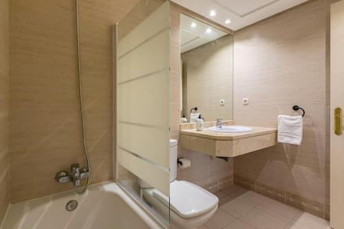 y baño con aseo, lavabo y ducha. en Luminous apartment in Puerto Banús, Marbella en Marbella