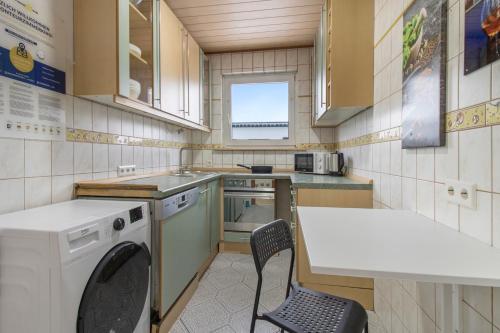 cocina pequeña con mesa y lavadora en Workers Apartment in Velbert, en Velbert