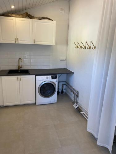 a kitchen with a washing machine and a sink at Feriehus Skagen in Skagen