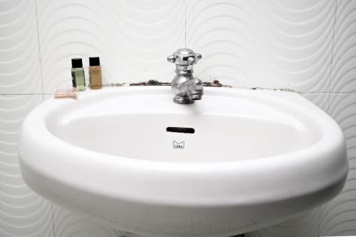 lavabo blanco con grifo en el baño en Cliff Heaven, en Colva