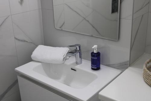 a bathroom sink with a bottle of soap on it at Hypnos Residence in Nicosia