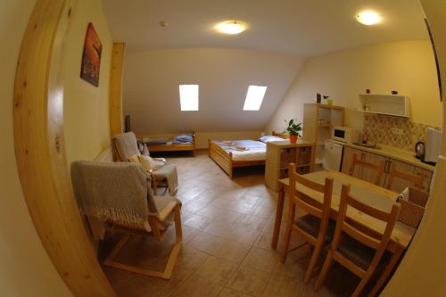 a kitchen and a living room with a table and chairs at Penzion Hradební in Telč