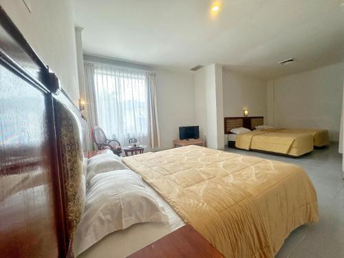 a bedroom with a large bed and two beds at Hotel Wisata Indah Sibolga in Sibolga